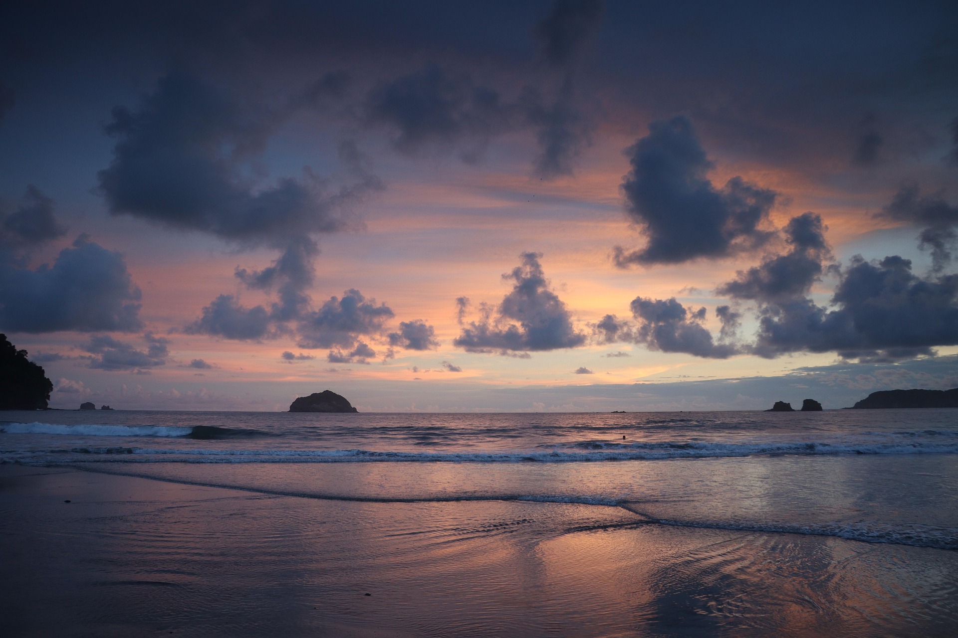 Stunning tropical beach sunset in Costa Rica with dramatic clouds and gentle waves